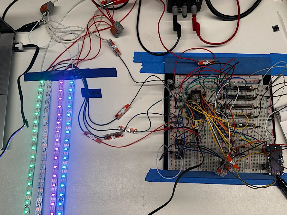 Prototype 1 on the bench: breadboard with the ESP32 and sliders driving four lit LED strips