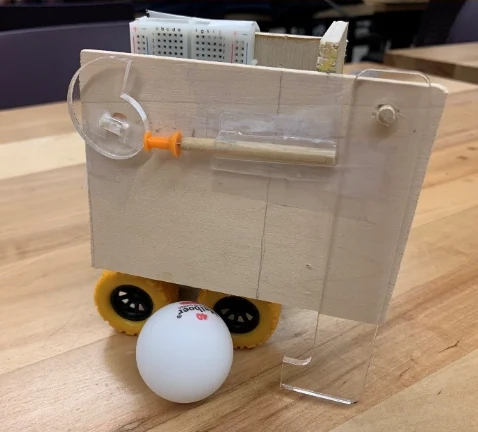 The finished toy with a ping-pong ball under its acrylic leg